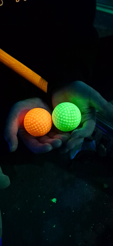 Leuchtende Golfbälle beim Schwarzlicht-Minigolf im Eiland van Maurik